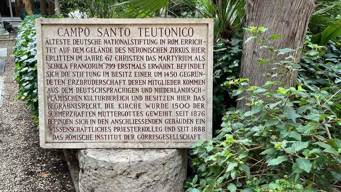 die-inschrift-des-steins-auf-dem-friedhof-des-campo-santo-teutonico-fasst-dessen-geschichte-kurz-und-buendig-zusammen-foto-deutsche-bischofskonfere5051365