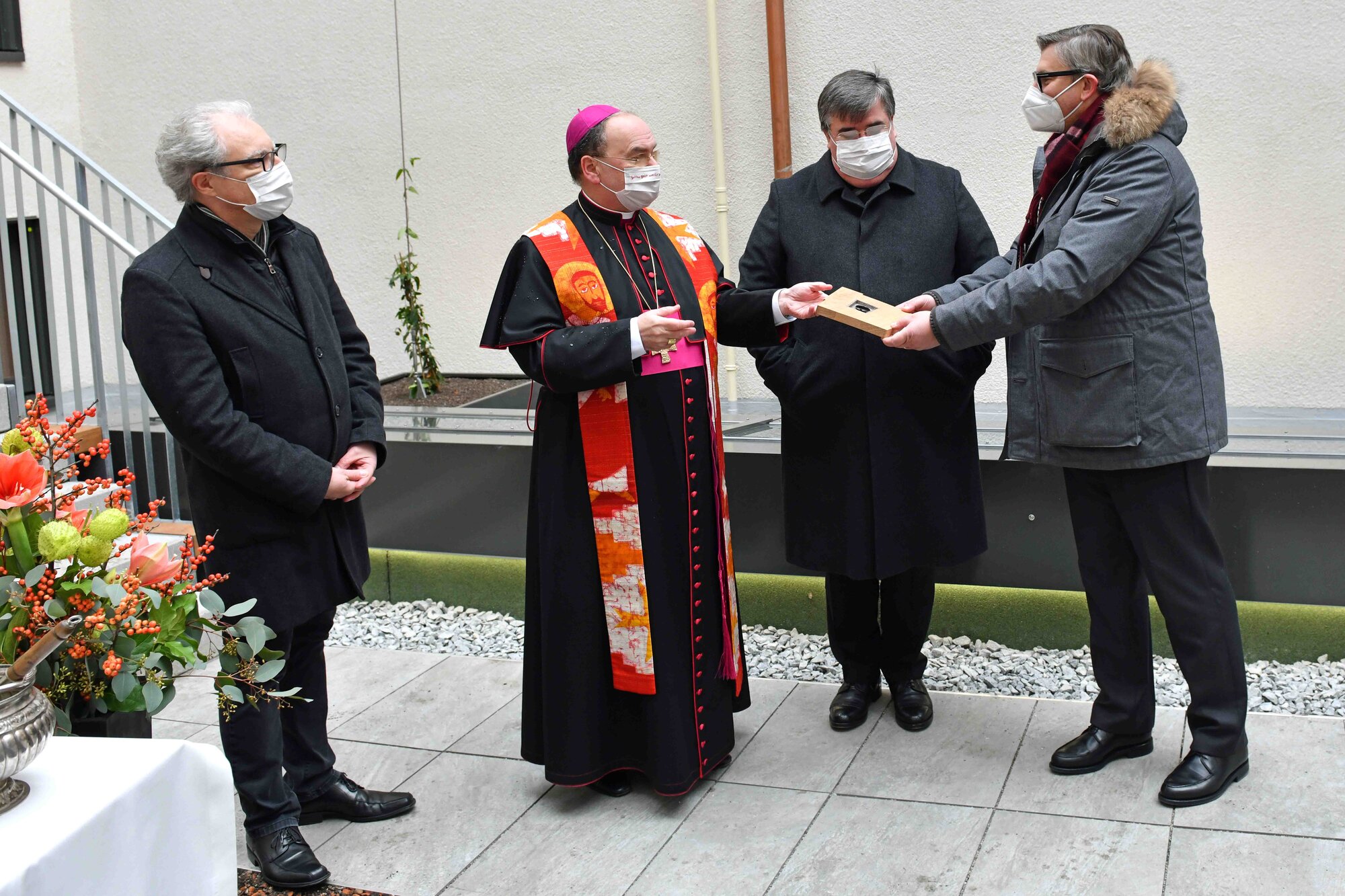 Bischof Bertram reicht die Chipkarte an Finanzdirektor Quella weiter.