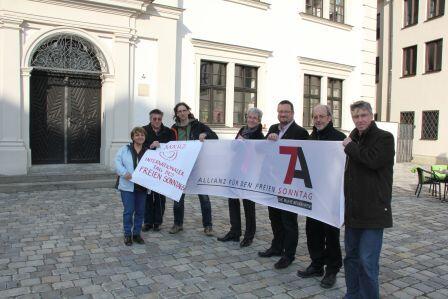 V.l. Neyla Sevinchan (Afa Augsburg), Eugen Hänel (kda Augsburg), Bernhard Stappel (Kath. Betriebsseelsorge Augsburg), Peter Ziegler (KAB Augsburg), Stefan Blumtritt (Evang. Dekanat Augsburg), Erwin Helmer und Lothar Roser (beide KAB Augsburg) bei der Plakatenthüllung im Augsburger Annahof.