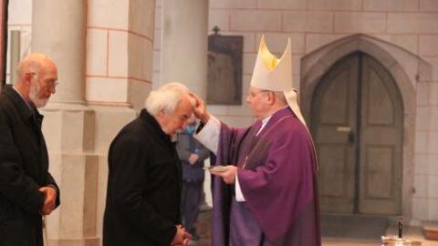 Bischof Zdarsa teilt das Aschekreuz an die Gemeinde aus.