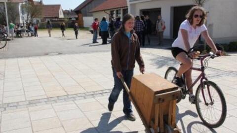 Mädchen beim Rätschen mit großer "Schubkarrenrätsche"