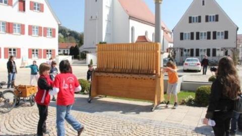 Zwei Buben betätigen die "größte Rätsche der Welt".