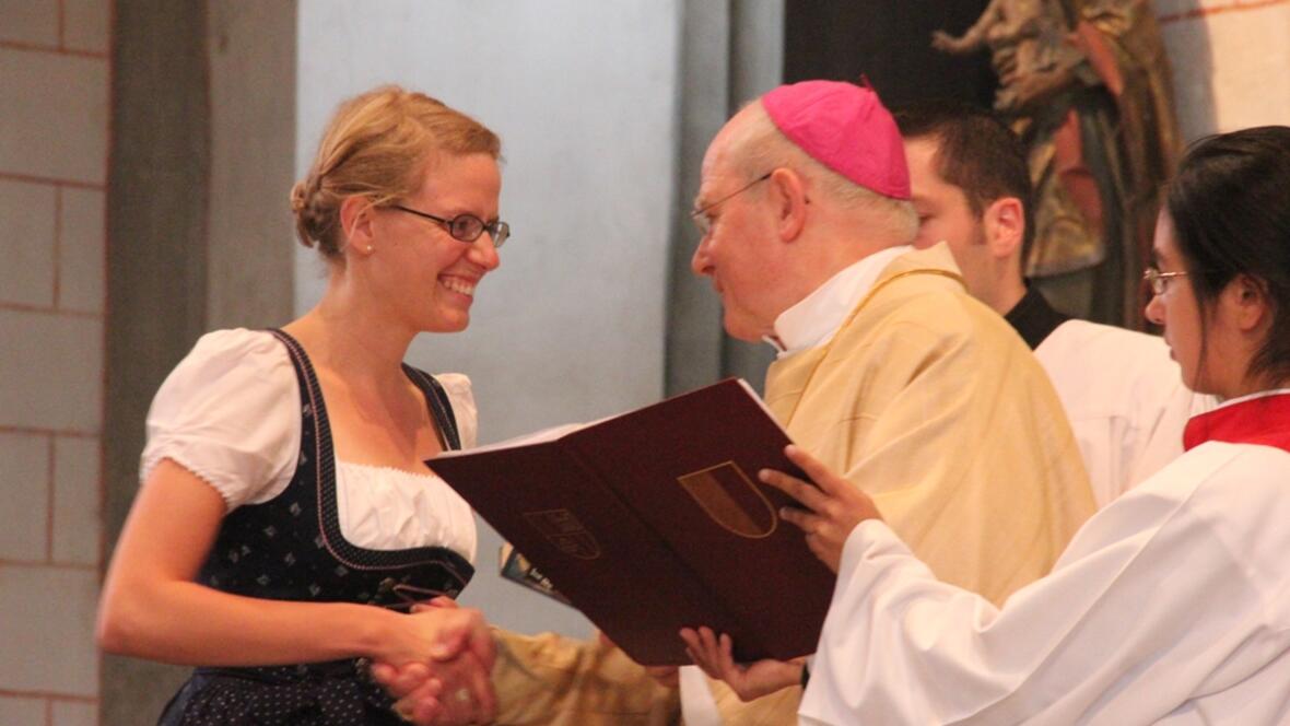 Bischof Konrad Zdarsa übergibt der neu ausgesandten Gemeindereferentin Maria Klaus die Heilige Schrift. 