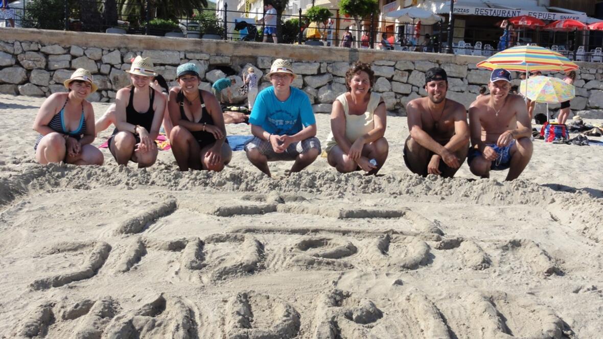 Matthias Matuschka (2.v.r.) und Annemarie Leis (3.v.r.), BDKJ Geschäftsführerin, bauen im Sand das WJT Logo.