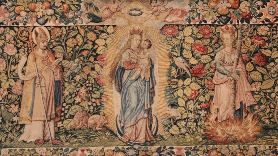 Auf dem Wandteppich sind die beiden Bistumspatrone Ulrich und Afra zu sehen und in der Mitte die Jungfrau Maria. 