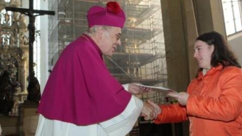 Weihbischof Josef Grünwald überreicht Ursula Bertele das Abschlusszeugnis des bestandenen C-Kurses.
