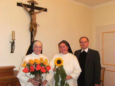Sr. Bernarda Reiter (links) mit einem Strauß guter Wünsche, Sr. Teresa Westermeier (Mitte) mit einer Sonnenblume als Hoffnungszeichen für die Zukunft und Prälat Bertram Meier (rechts).