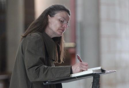 Eine Gläubige trägt sich in das Glückwunschbuch für Bischof Zdarsa ein.