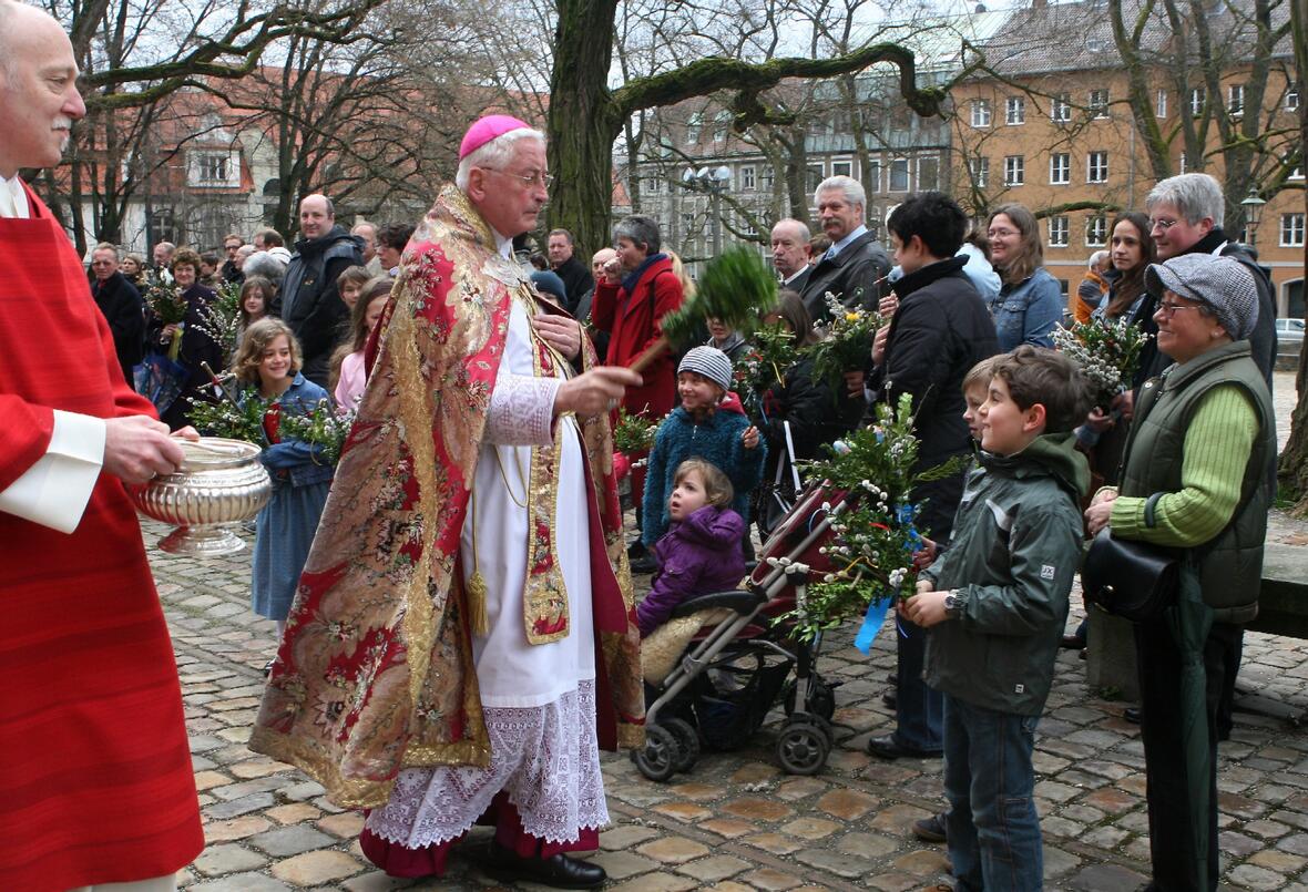 Bischof Dr. Walter Mixa segnet die Palmzweige der Gläubigen vor dem Augsburger Mariendom.