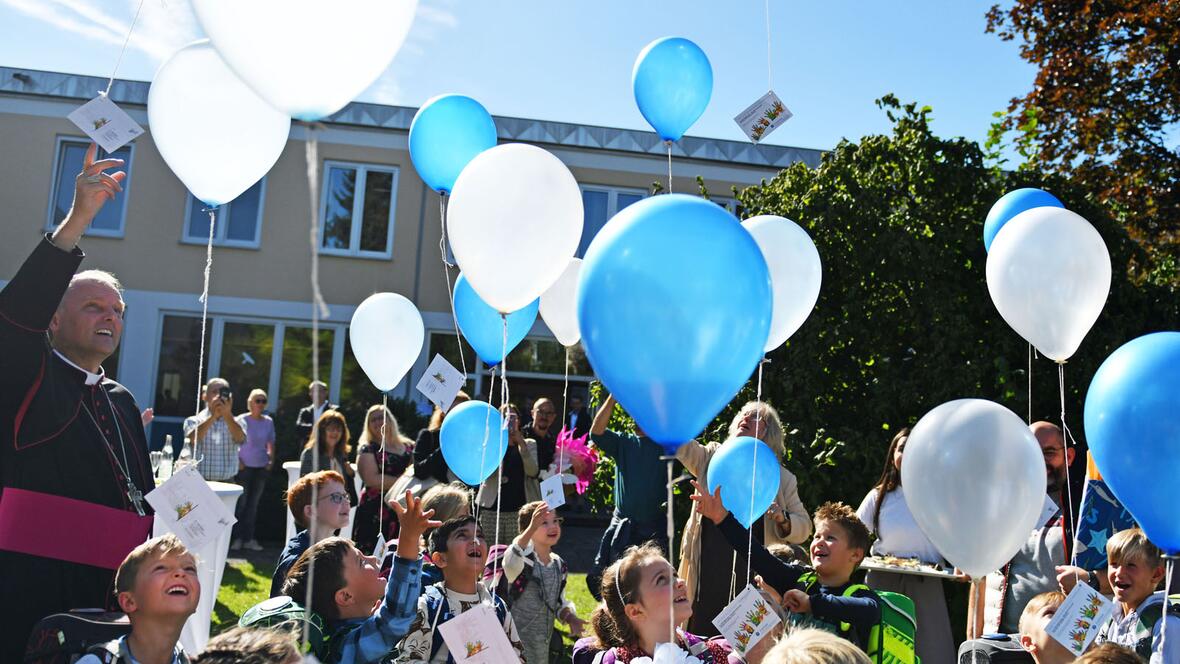 Himmelhoch jauchzend: Weihbischof Florian Wörner lässt gemeinsam mit den Erstklässlern der neuen Grundschule Luftballons steigen (Fotos: Julian Schmidt / pba)