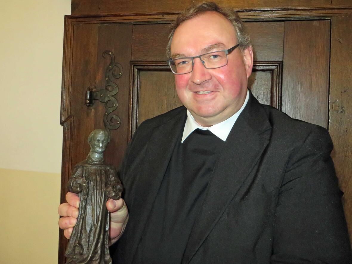 Dekan Stefan Gast hält den „eisernen Leonhard“ in seinen Händen, der beim Leonhardiritt festlich geschmückt auf einer Stange durch die Straßen von Inchenhofen getragen wird. (Foto: Viktoria Zäch / pba)