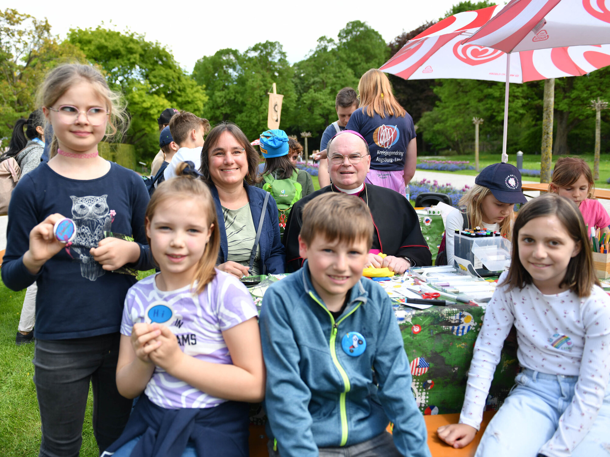 Bischof Bertram und die zweite Oberbürgermeisterin von Augsburg, Martina Wild, haben an dieser Station gelernt, wie man Buttons herstellt. (Foto: Maria Rösch / pba)