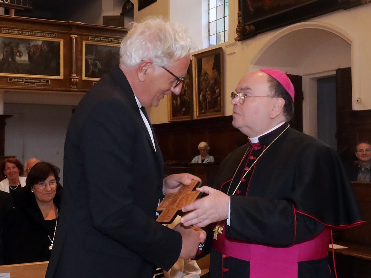 Zum Abschied ein Ulrichskreuz: Bischof Bertram mit dem scheidenden Regionalbischof Axel Piper (Foto: Annette Zoepf / pba).