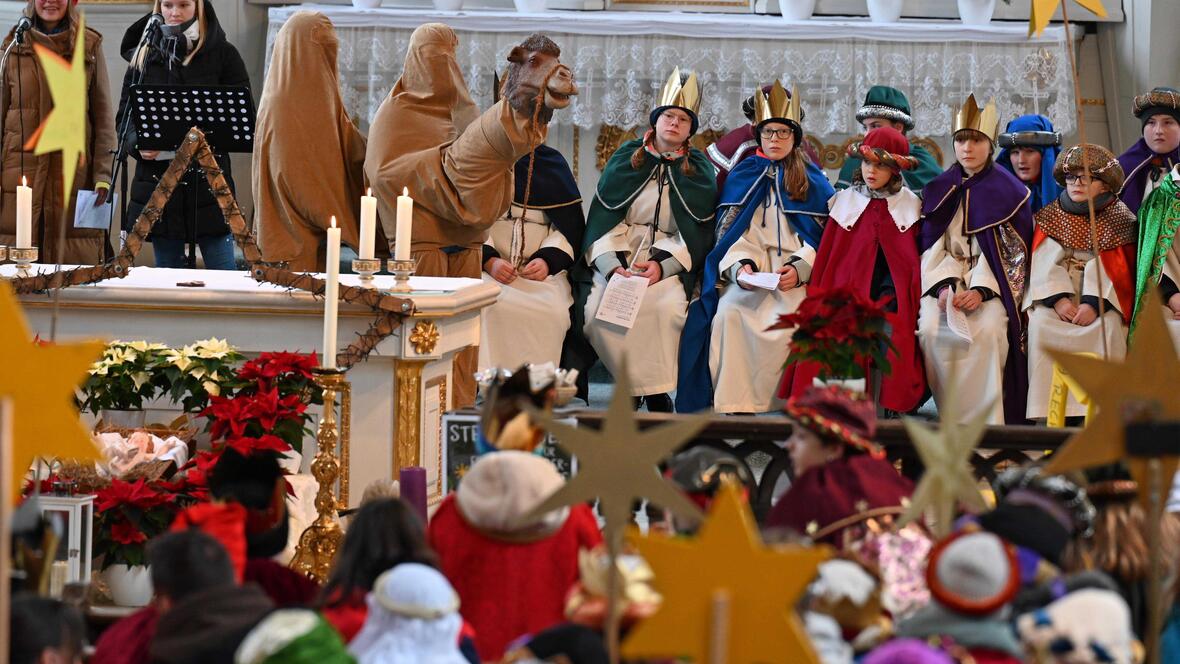 Sternsinger mit Kamel im Altarraum der Pfarrkirche Mariä Himmelfahrt. 