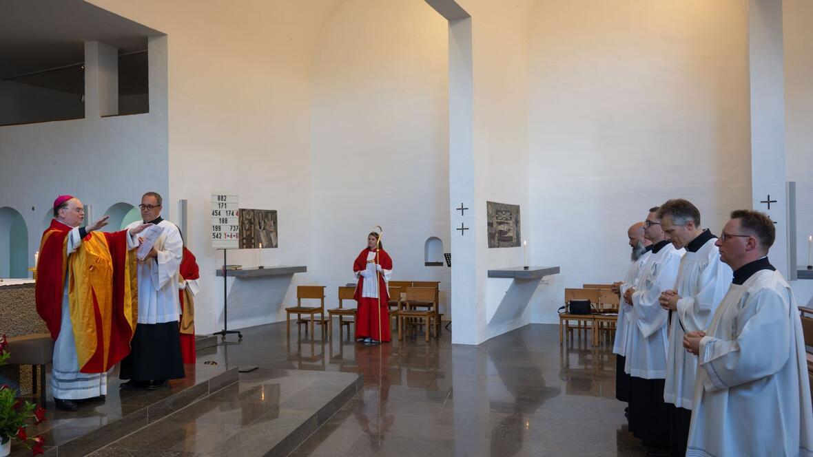 Der Bischof spricht den Segen über die vier Männer.