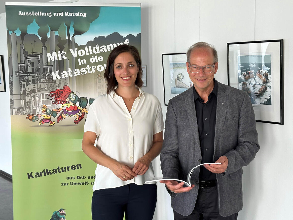 Referentin, Dr. Daniela Kaschke und Dr. Christian Hartl, Leiter des Exerzitienhauses, freuen sich über die Karikaturenausstellung im Haus. (Foto: Exerzitienhaus Leitershofen)