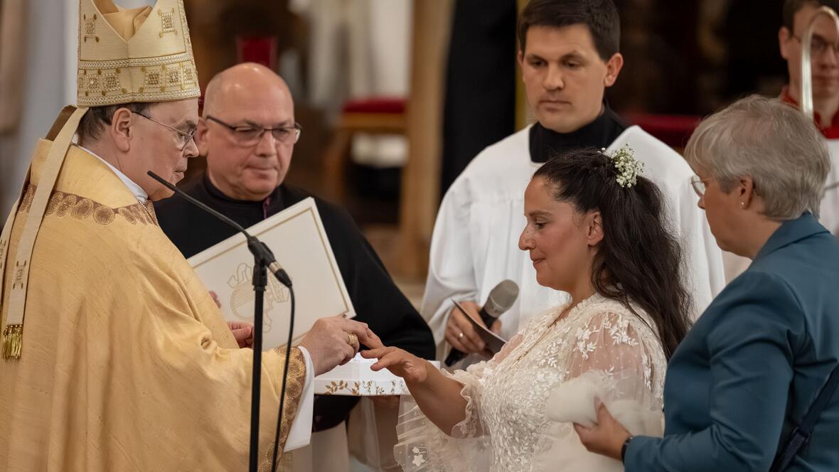 Bischof Bertram steckt der geweihten Jungfrau den Ring als Zeichen ihrer Bindung an Christus an.