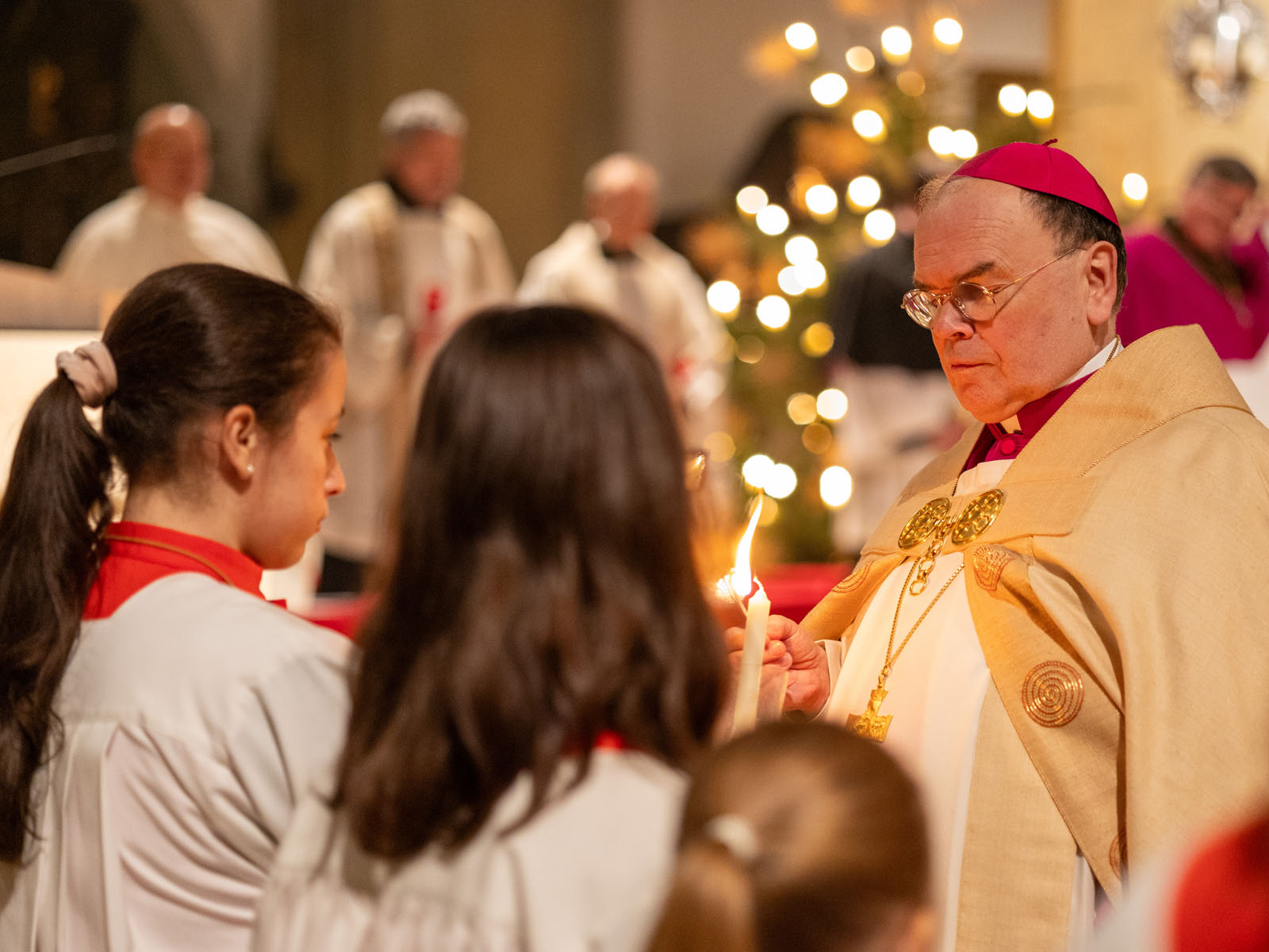 Bischof Bertram teilt das Licht in der Ulrichsbasilika aus (Foto: Julian Schmidt / pba)